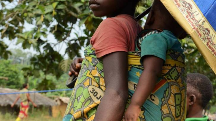 young girl with baby on her back