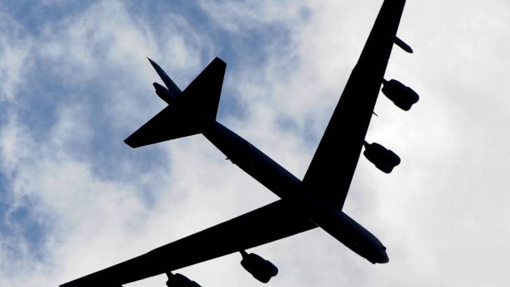 silhouette of a jet against clouds