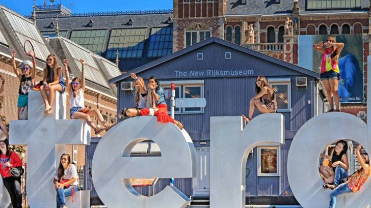 dutch women standing on a sign out doors of a museum