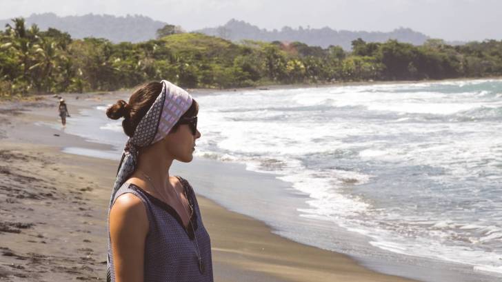 woman on beach staring out to the ocean
