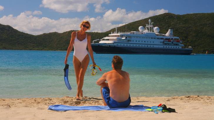 couple on beach with cruise ship in the background