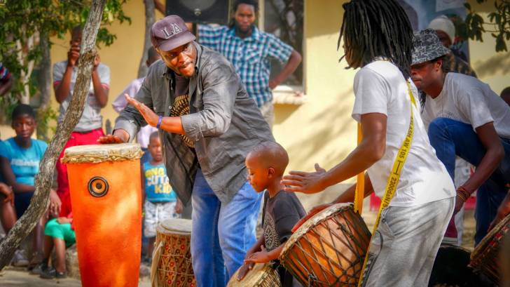 group of people playing african drums celebrating