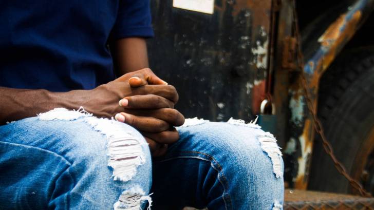 black man holding hands hopeful