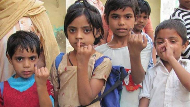kids in india showing finger mark to prove polio vaccinated