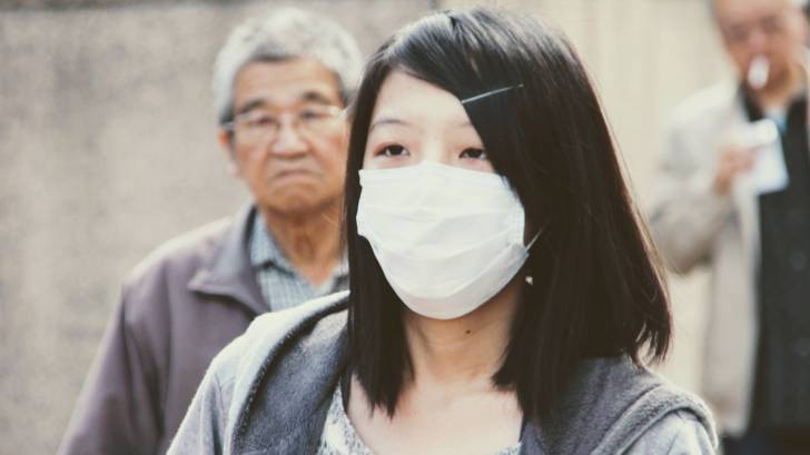 woman with a mask on to protect from the flu