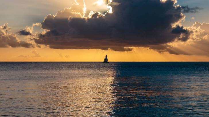 atlantic ocean sunset, yellow with sail boat in the back ground