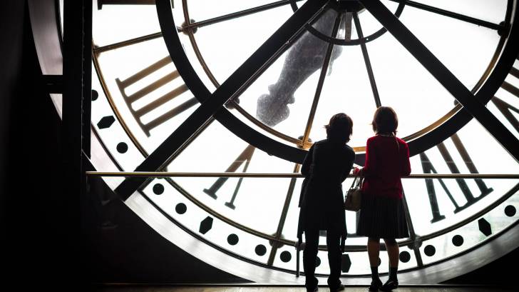 women standing in front of a huge clock