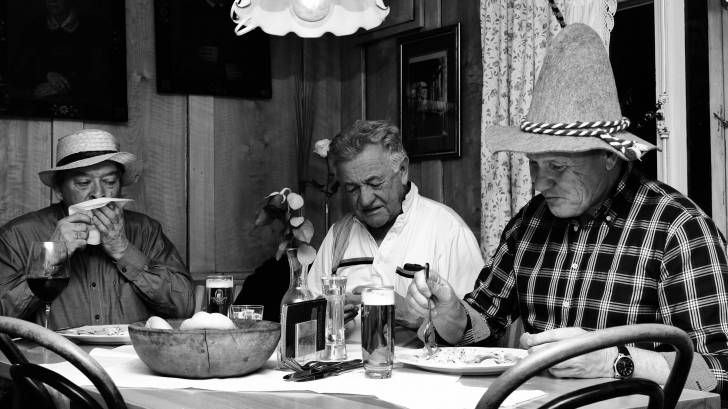 3 older men enjoying a meal with each other