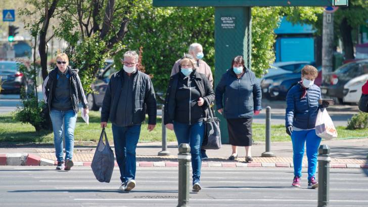 people wearing masks crossing the road