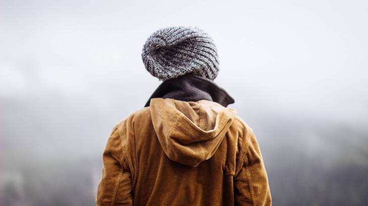 man looking forlornly into the foggy mist