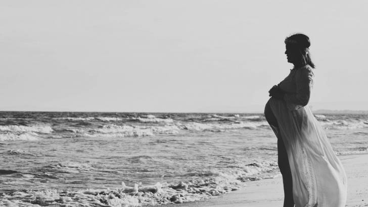 pregnant women looking out at the caribbean sea