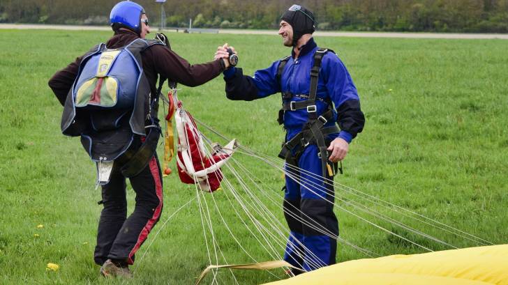 parachutists shaking hands after landing