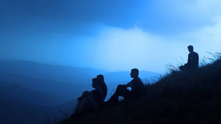 men sitting on a hill, silhouettes, looking for answers