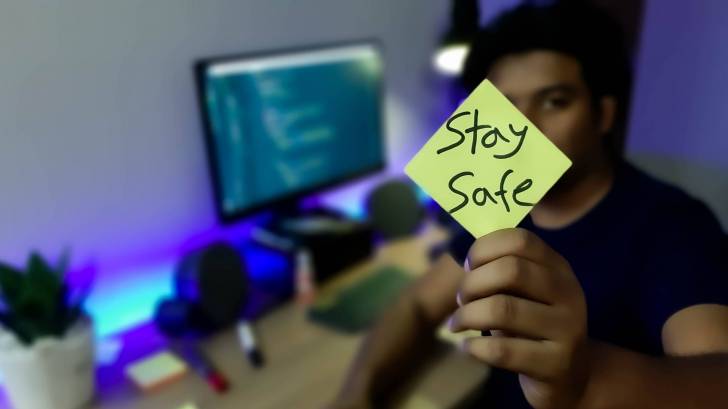 home worker showing stay safe sign