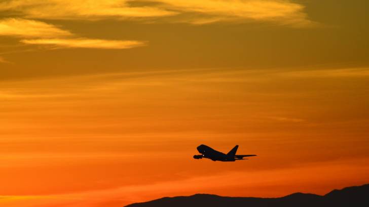 jet taking off into the sunset from China