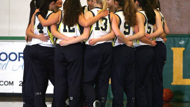 girls basketball team hugging