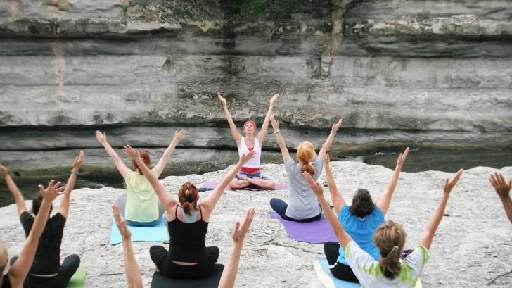 women taking a yoga class raising their arms to the sky