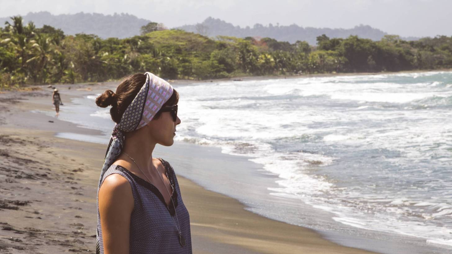 woman on beach staring out to the ocean