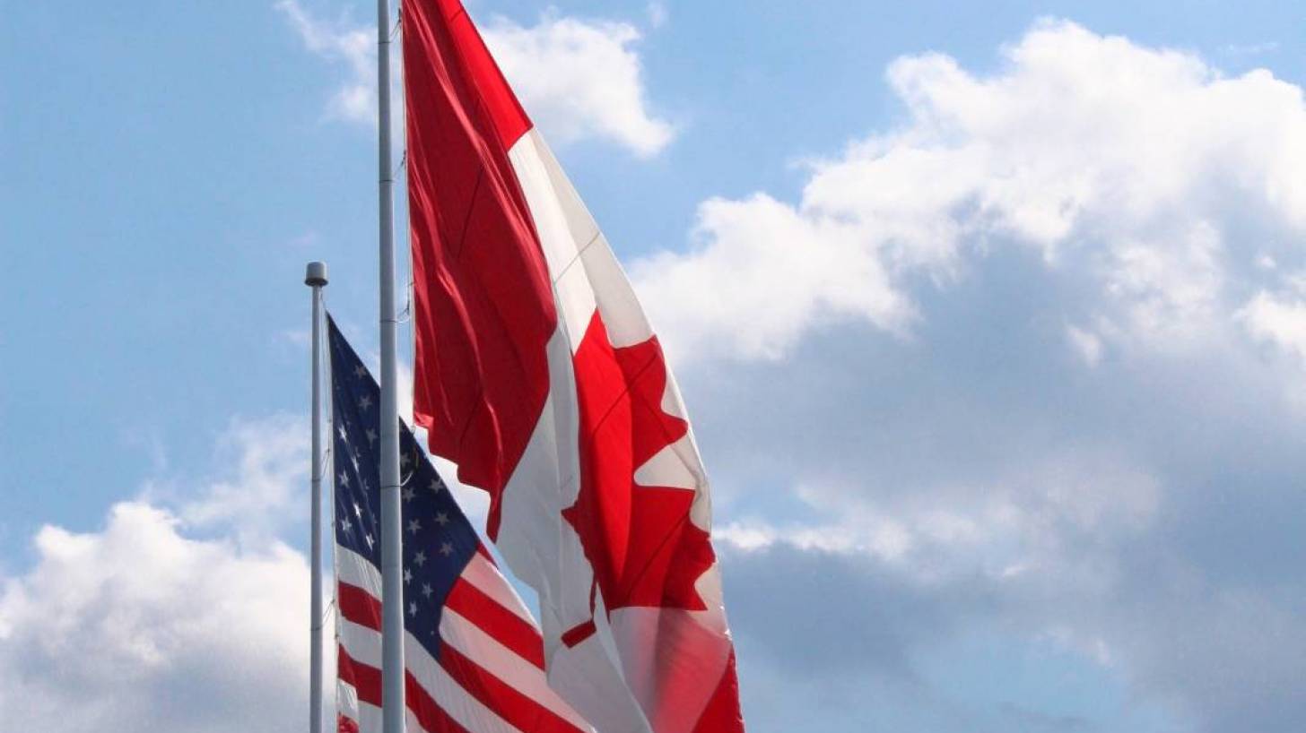 us and canada flags flying together