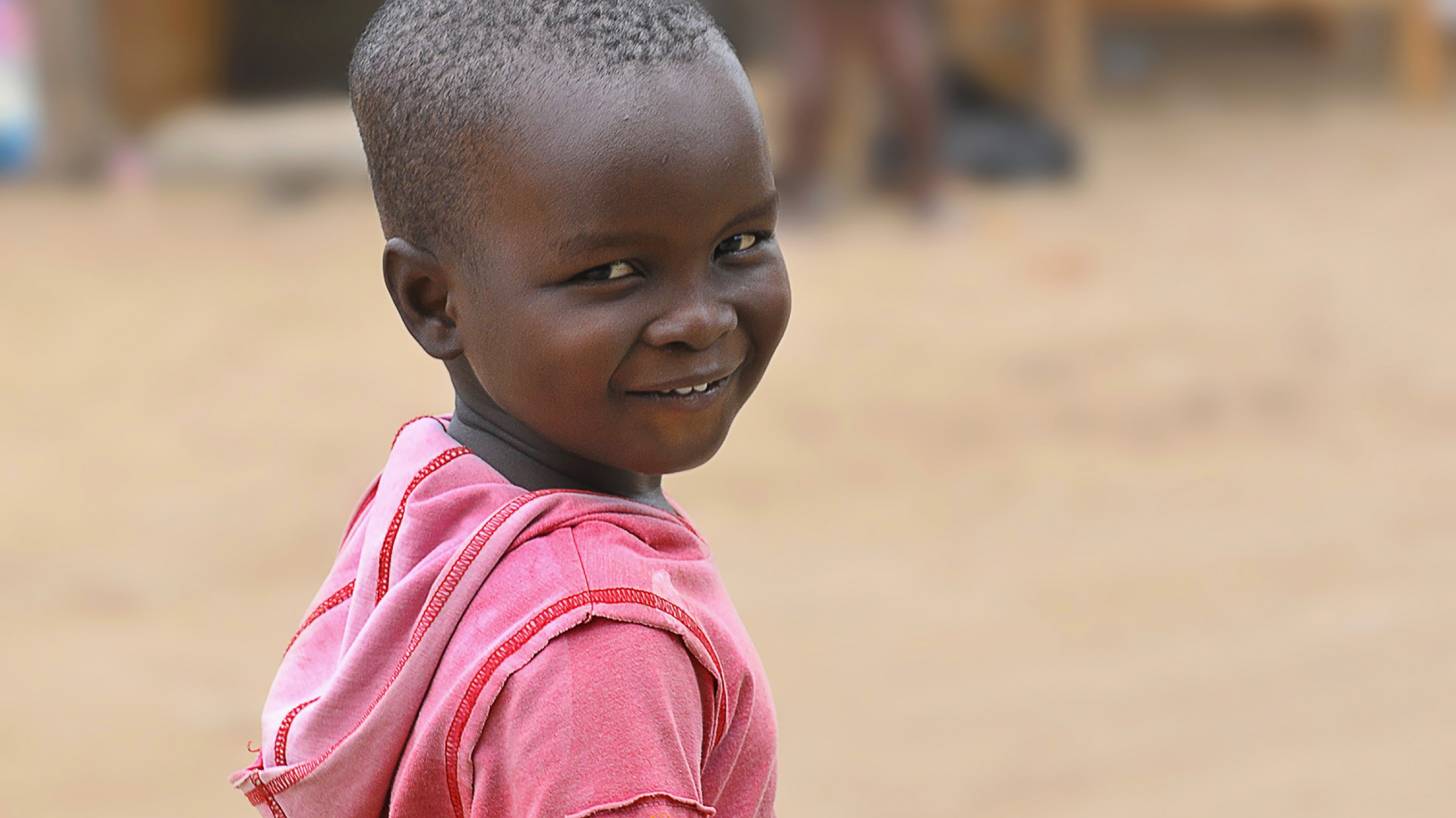 young african boy smiling in a red shirt
