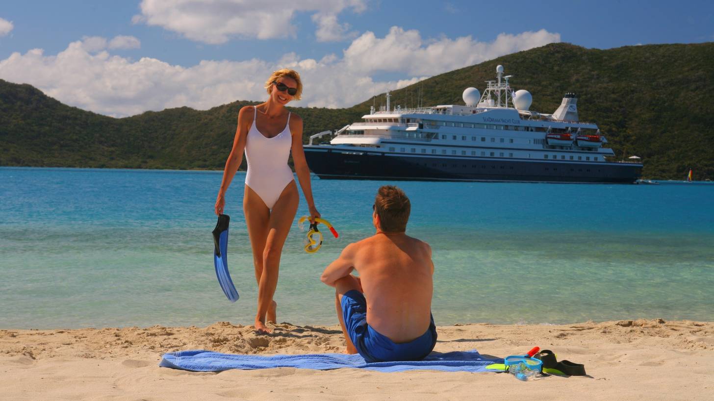 couple on beach with cruise ship in the background