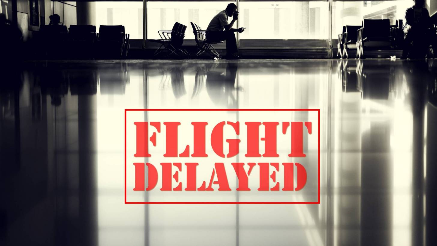 airport with sign saying flight delayed