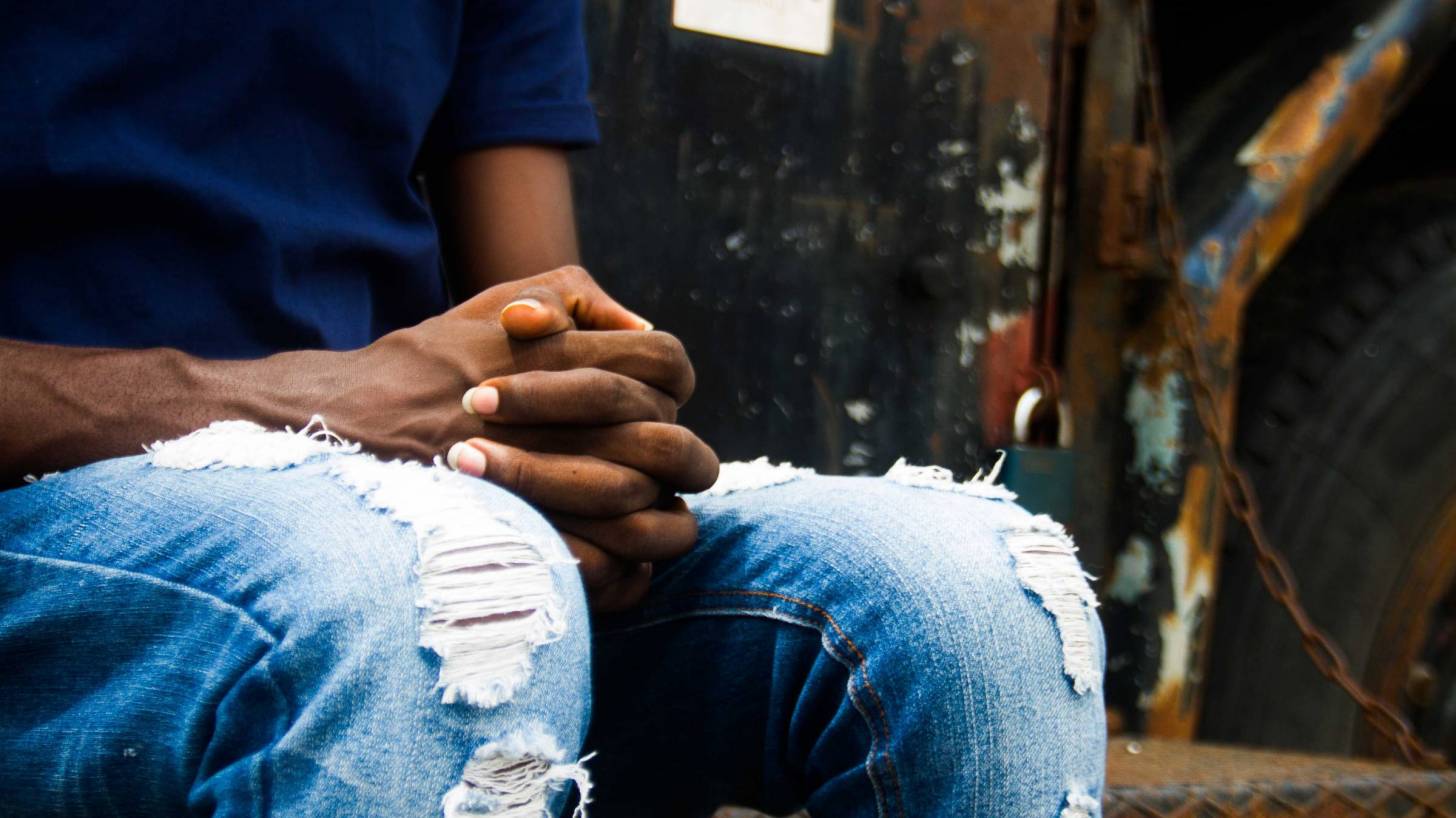 black man holding hands hopeful