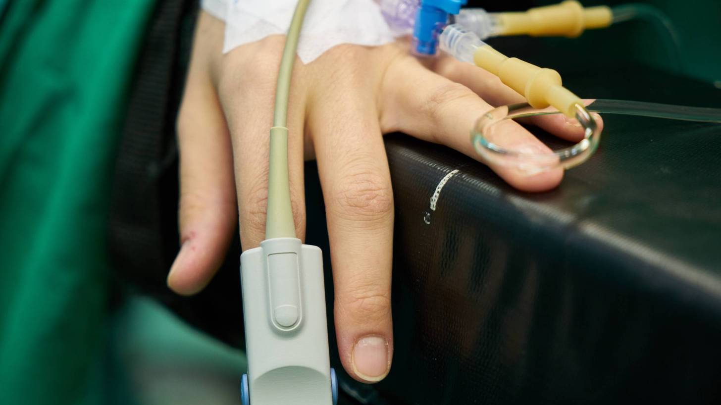 hospital care for a man, monitor on finger
