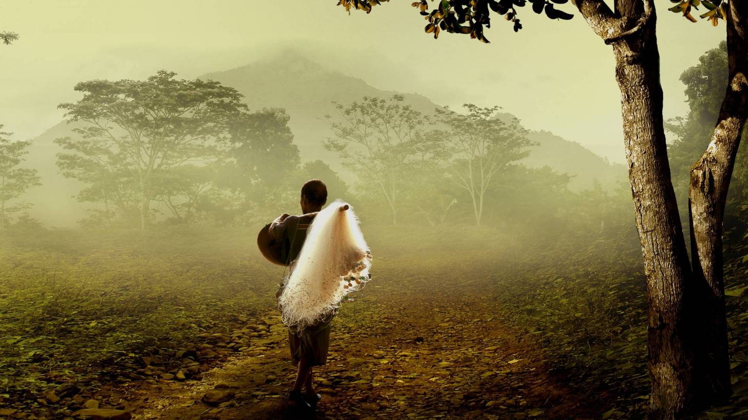 thai fisherman walking in the woods with fog