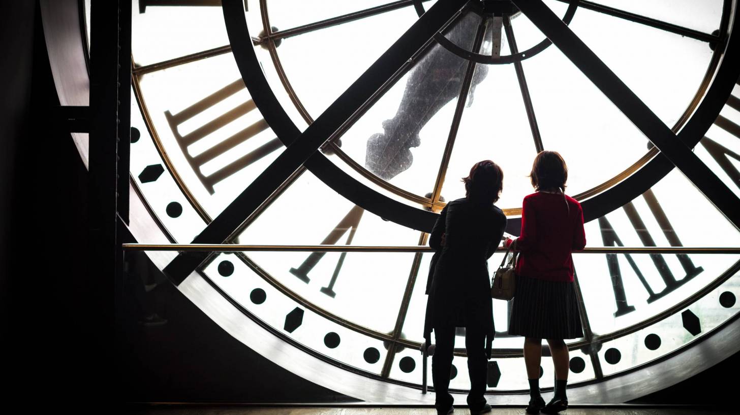 women standing in front of a huge clock
