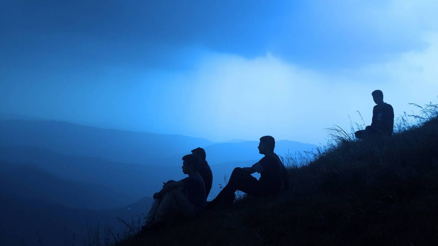 men sitting on a hill, silhouettes, looking for answers