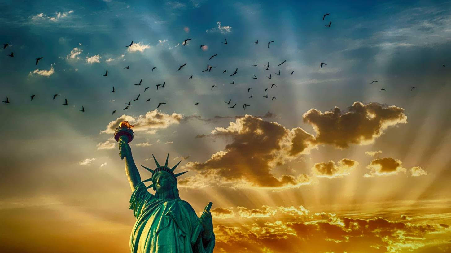 staute of liberty with clouds in the background