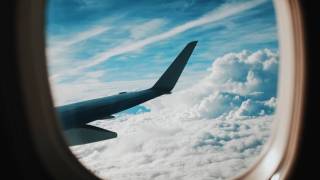 looking out airplane window towards the wing and clouds