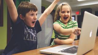 children happy looking at a computer screen