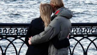 young couple hugging on a bridge