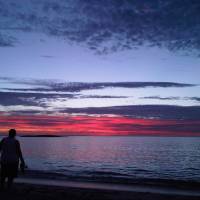 sun setting on beach couple walkiing