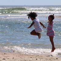 children jumping high in the ocean
