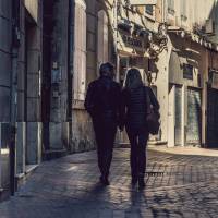 older couple walking thru an old town in europe