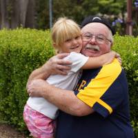 happy healthy grandpa hugging his grand daughter