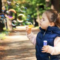young girl blowing bubbles