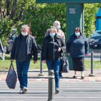 people wearing masks crossing the road