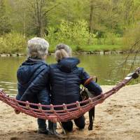 mom and her daughter sitting on a hamock looking at birds on a lake
