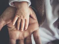 dad holding the hand of his toddler